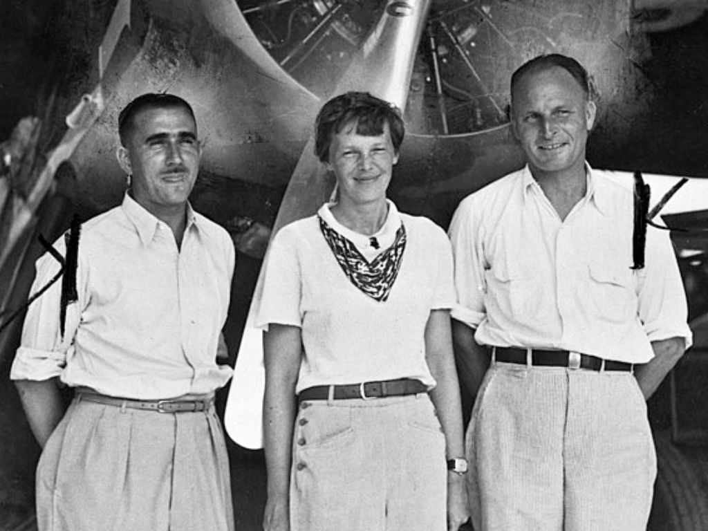 Amelia Earhart standing next to 2 other pilots