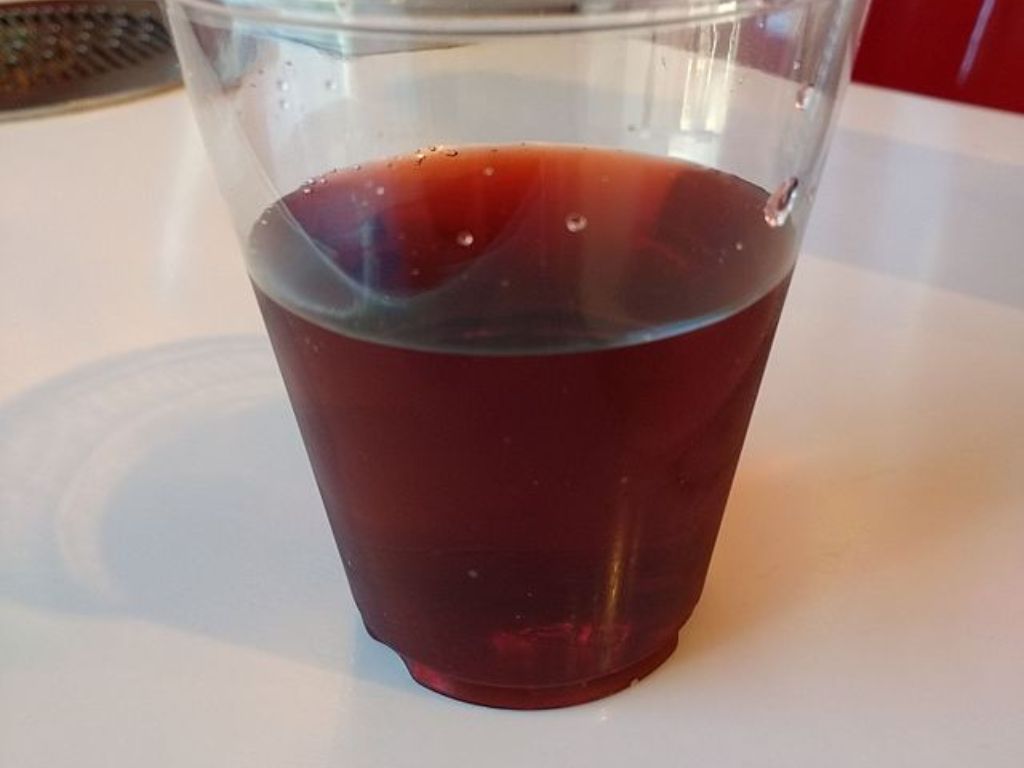 A plastic cup filled with Coca-Cola