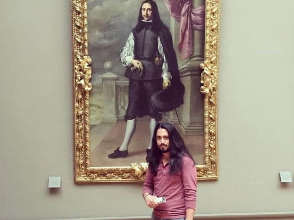 A man standing in front of a painting that looks like him