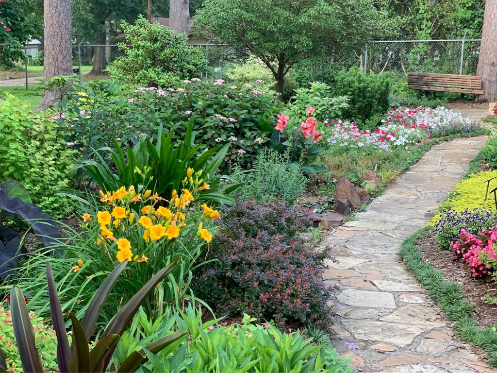 A lush, green garden with trees and flowers