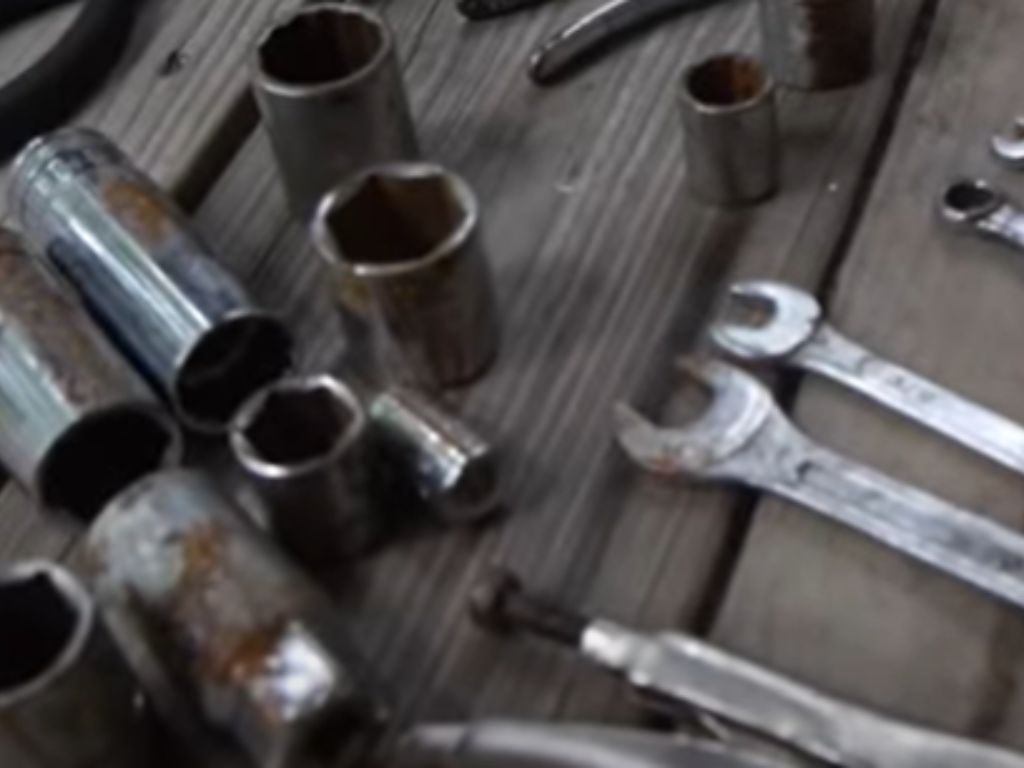 A bunch of rusty tools including wrenches and nuts