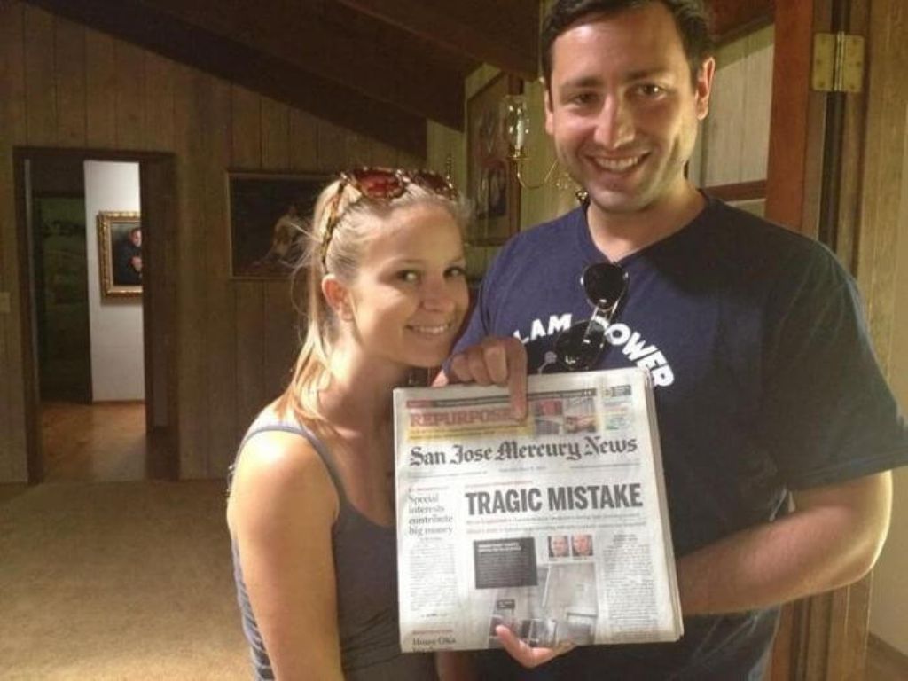 A newlywed couple holding a newspaper with a headline that reads "Tragic Mistake"