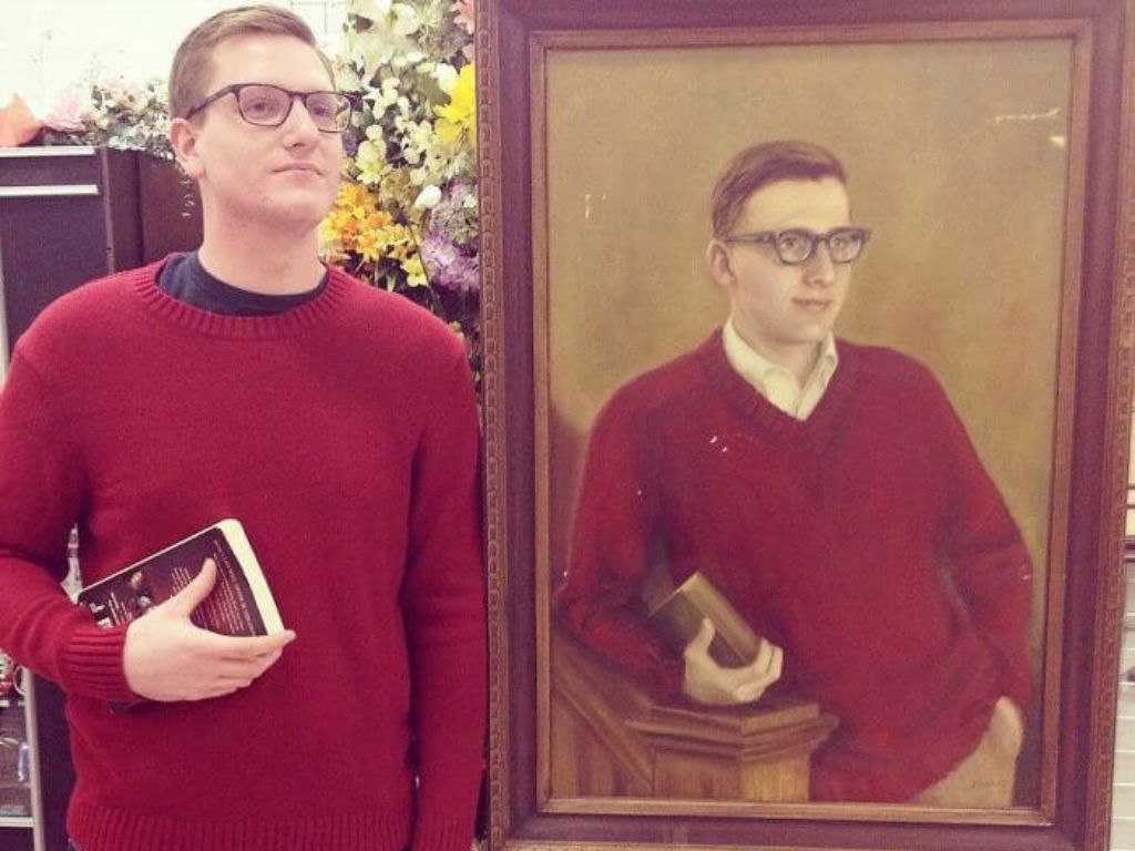 A man standing next to a painting that looks like him