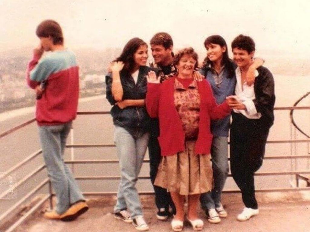 A man with his back turned to a group of people in an old photo