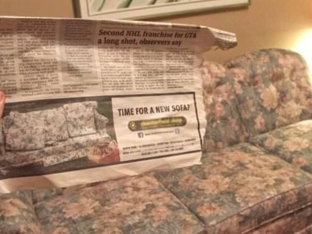 A newspaper that reads "time for a new sofa"