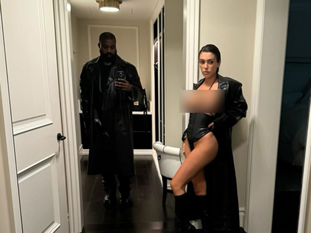 Kanye West taking a photo of his wife Bianca Censori on his phone.