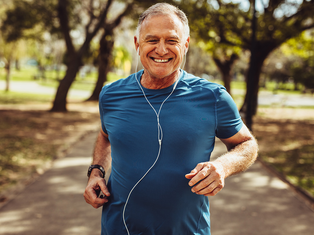 An older man with grey hair jogging