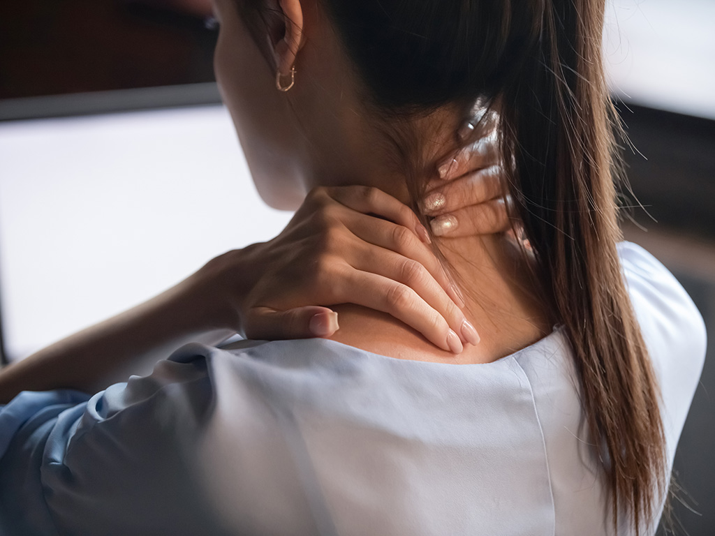 A woman with a headache rubbing her neck