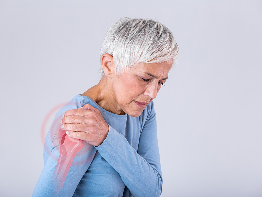 A woman gripping her shoulder