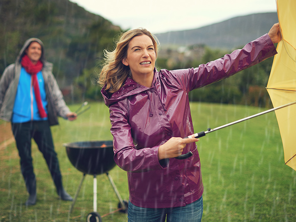 A woman with an umbrella looking into a storm.