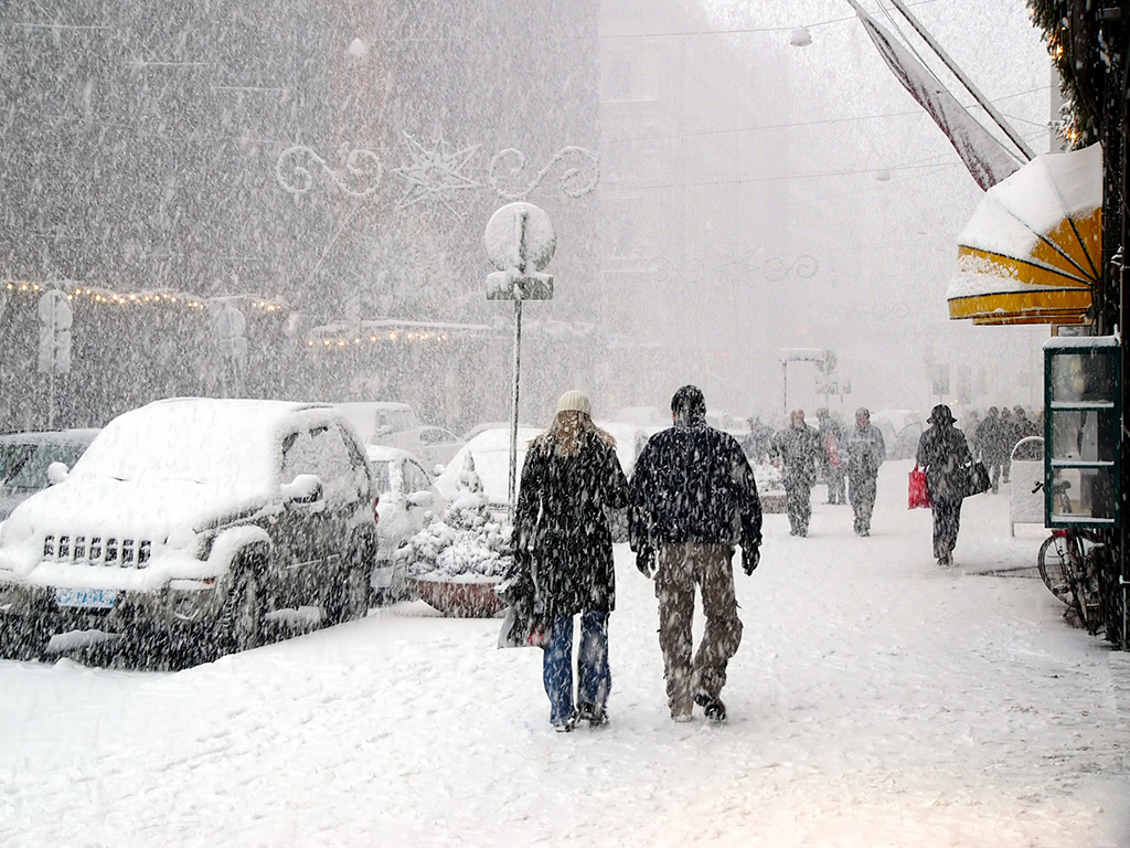 A couple walking on a snowy sidewalk