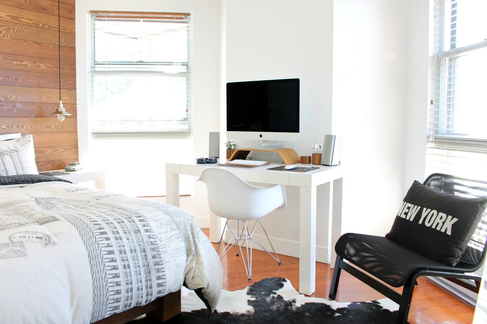 A sparse bedroom with a bed, chair and computer desk