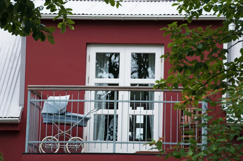 A baby carriage on a closed balcony