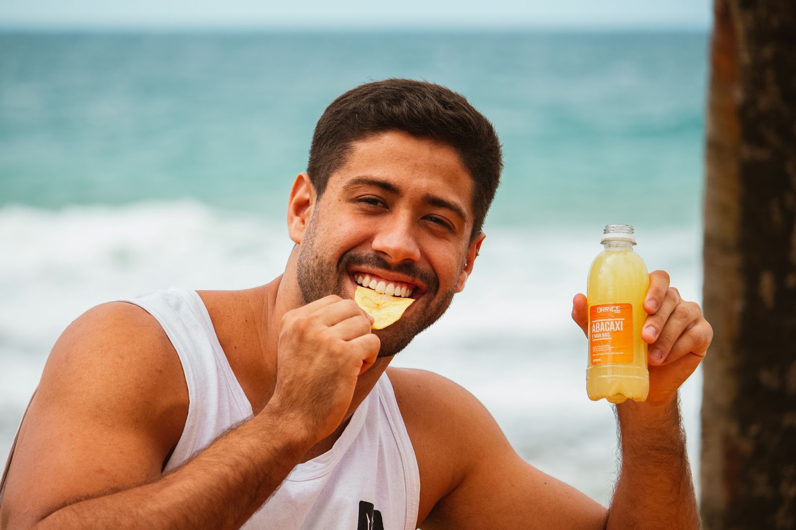 Man eating a potato chip while holding a beverage