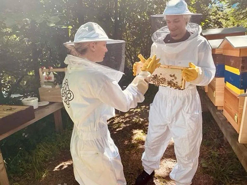 Millie Bobby Brown and Jake Bongiovi wearing beekeeping suits