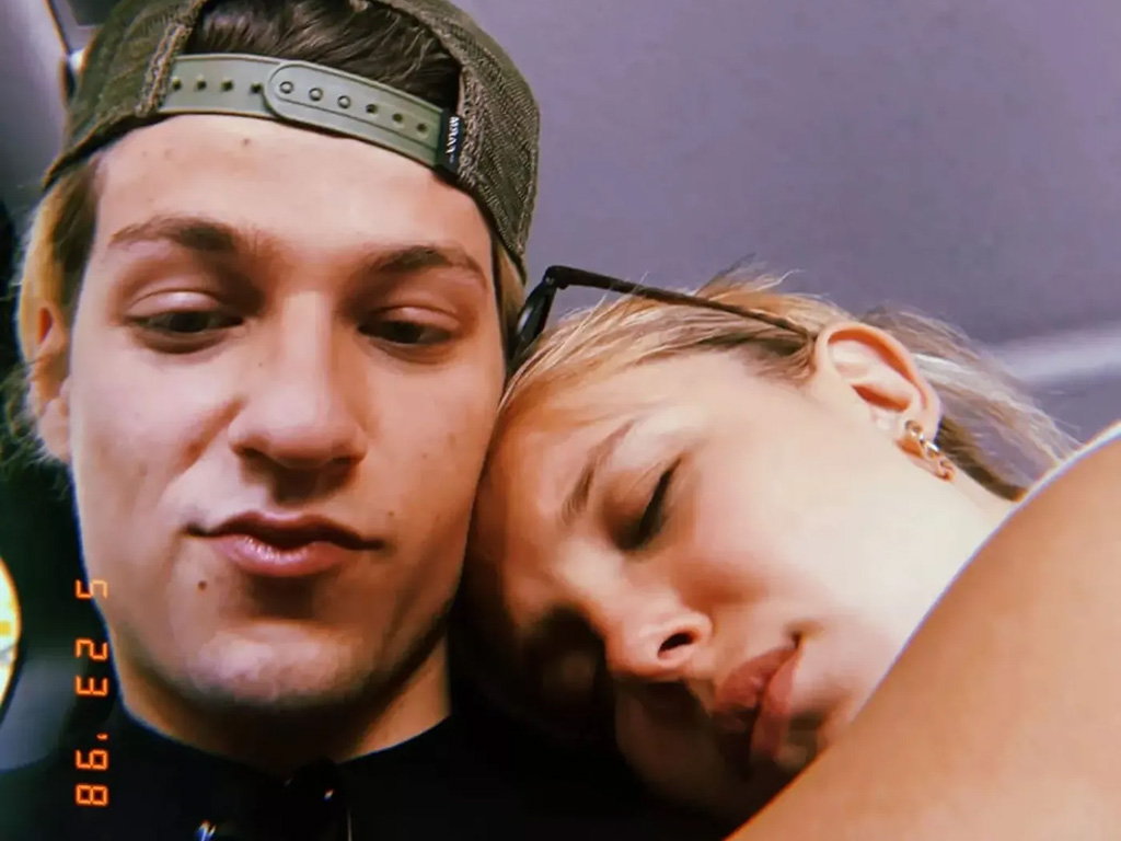 Millie Bobby Brown laying her head on Jake Bongiovi's shoulder 