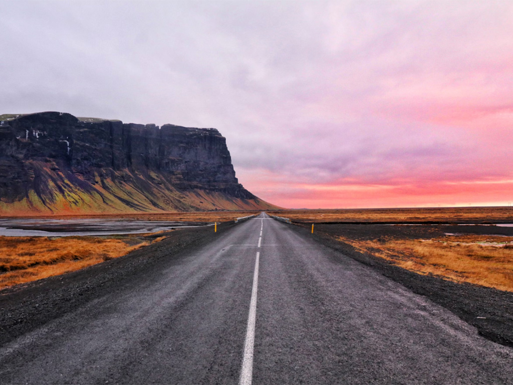 Icelandic road with a view of the sky and mountain cliffs