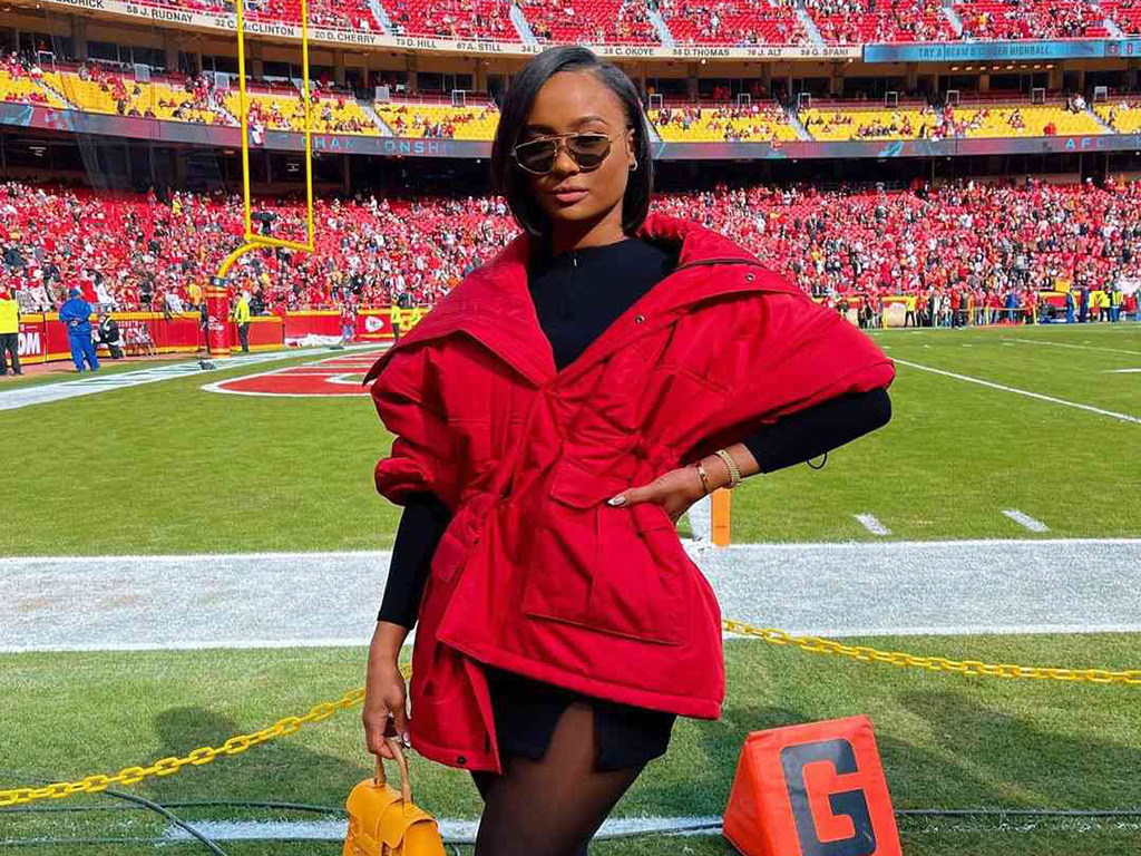 Kayla Nicole wearing a red coat on a football field