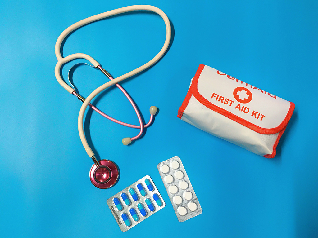 First aid kit supplies including pills and a stethoscope 