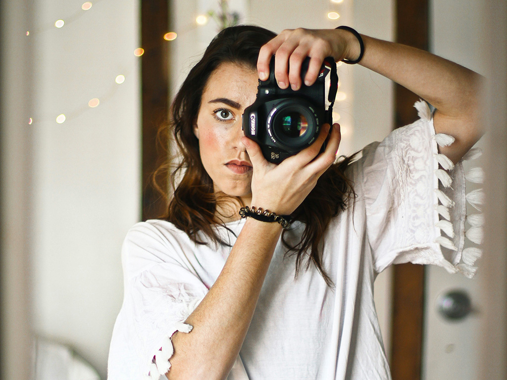 A woman taking a photo with a Canon camera