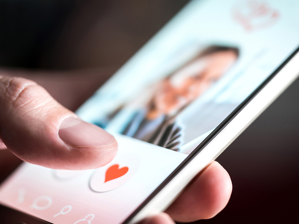 Dating app or site in mobile phone screen. Man swiping and liking profiles on relationship site or application. 