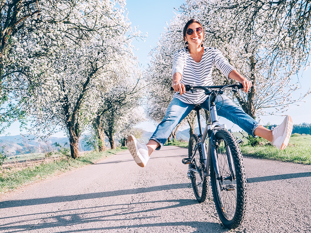 Woman riding a bicycle and kicking up her legs