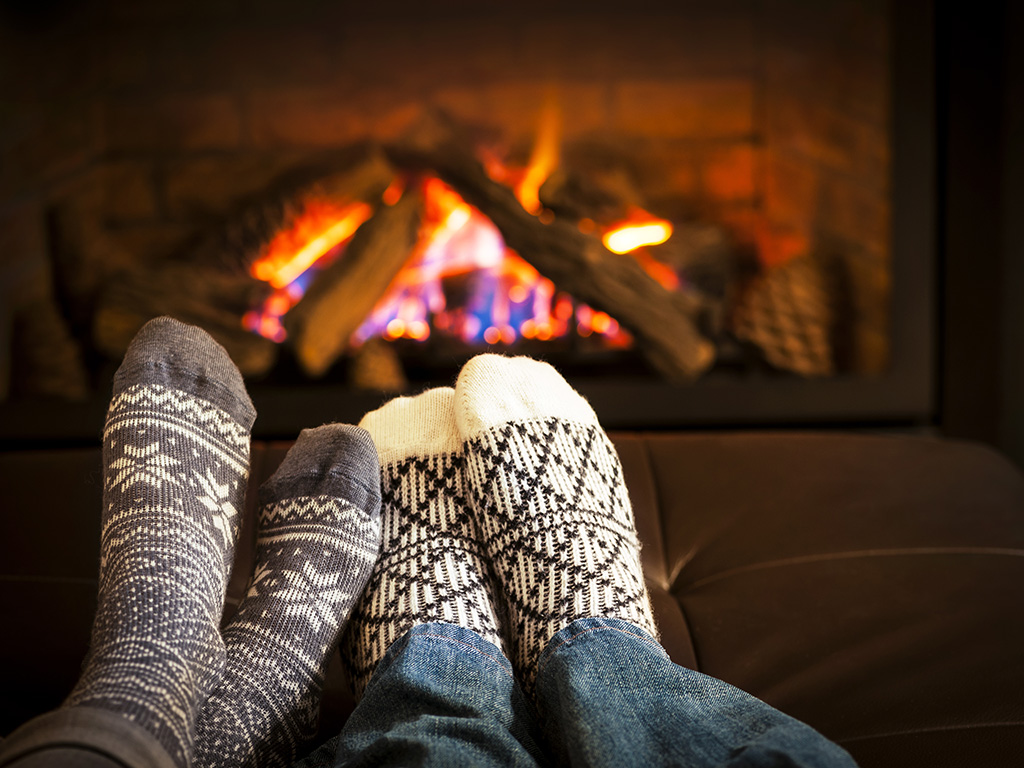 Feet in wool socks warming by cozy fire