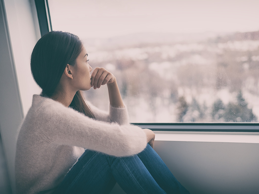 Asian girl with winter blues seasonal affective disorder feeling sad or heart broken 