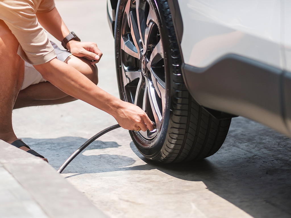 A person inflating their car's tires