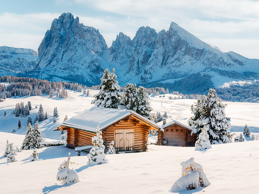 Picturesque landscape with small wooden log cabin on meadow Alpe di Siusi on sunrise time