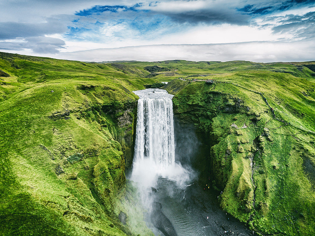 Gushing waterfall in a green landscape in Iceland