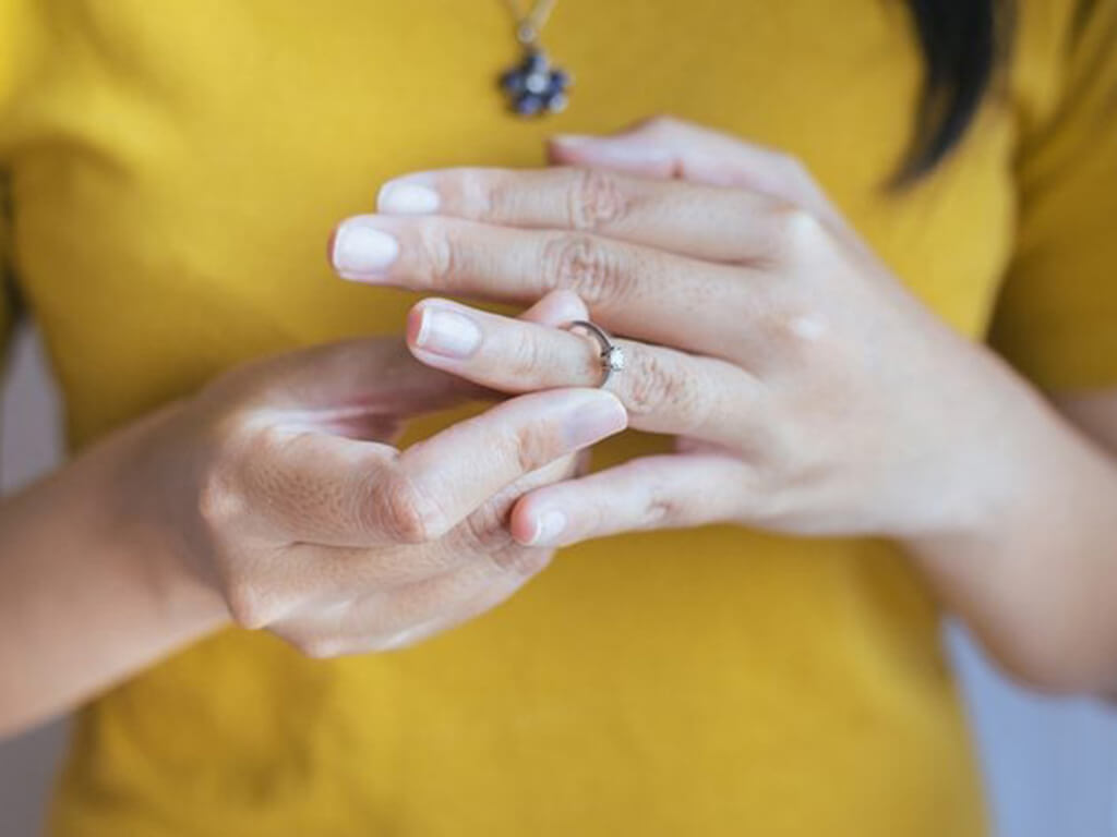 Woman twisting a ring off her finger