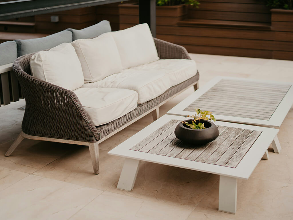 Outdoor seating area with wicker furniture and wooden tables