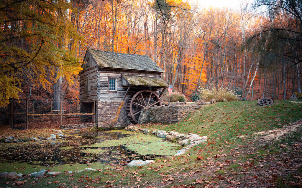 Beautiful autumn scene at Cuttalossa barn mill in Bucks County Pennsylvania with colorful fall foliage.