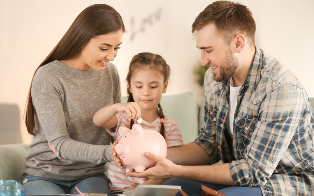 Family putting money in a piggy bank