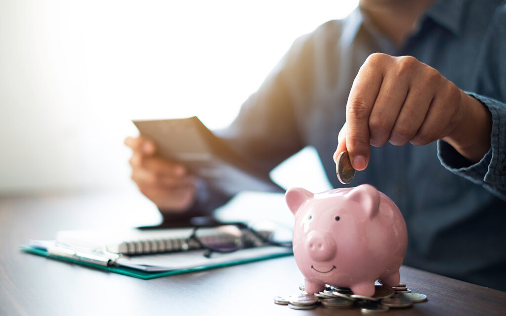 Person putting money in a piggy bank