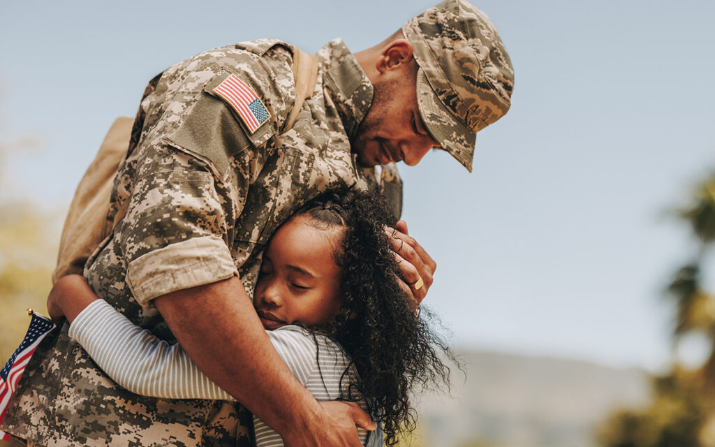 Man in military uniform hugging a girl